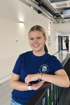 Blond tüdruk sinises Tartu Ülikooli särgis.